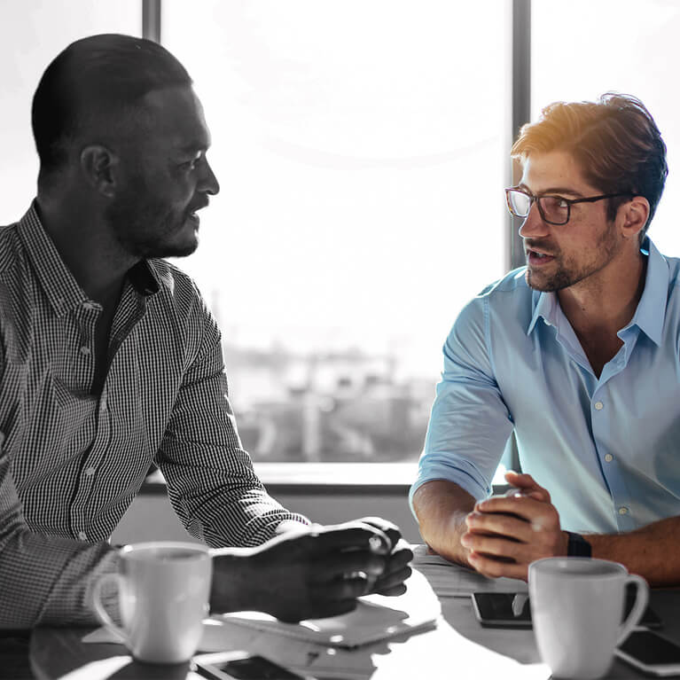 meeting with 2 men talking while they are having coffee